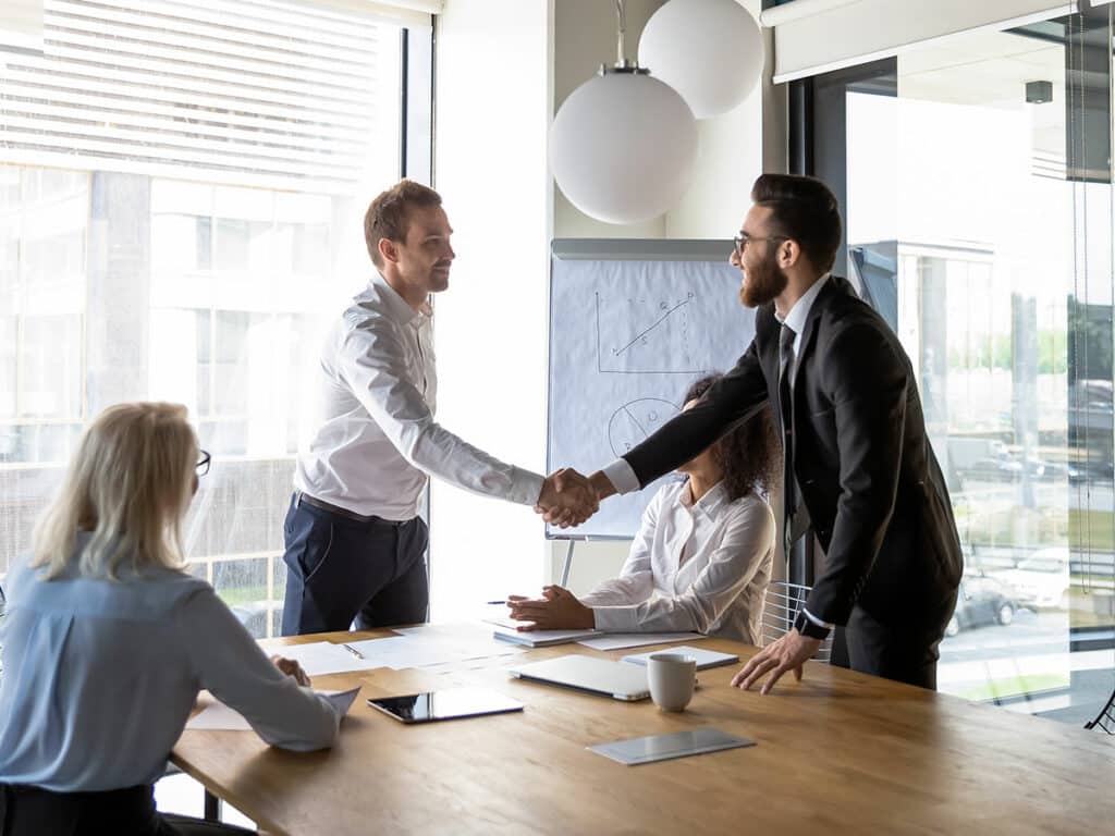 team skaing hands after deal has been made